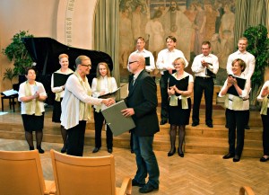 Kansallis-Kuoro luovuttaa nuottien alkuperäiskäsikirjoituksia Kansalliskirjastolle kevätkonsertissa 28.5.2015.